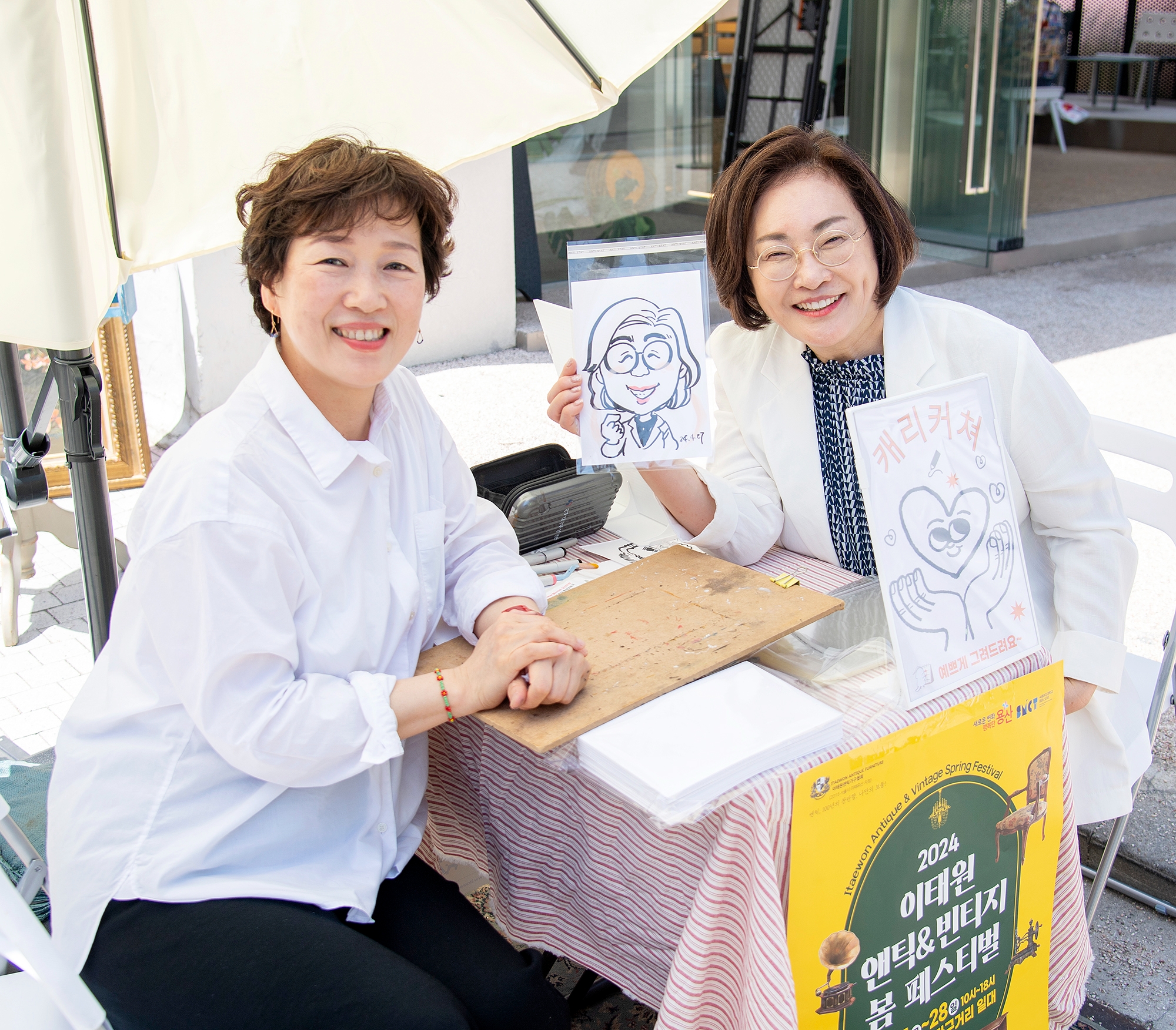 박희영 용산구청장이 2024 이태원 앤틱 빈티지 봄 페스티벌 행사에서 캐리커쳐 그려주기 체험하는 모습./사진제공=용산구