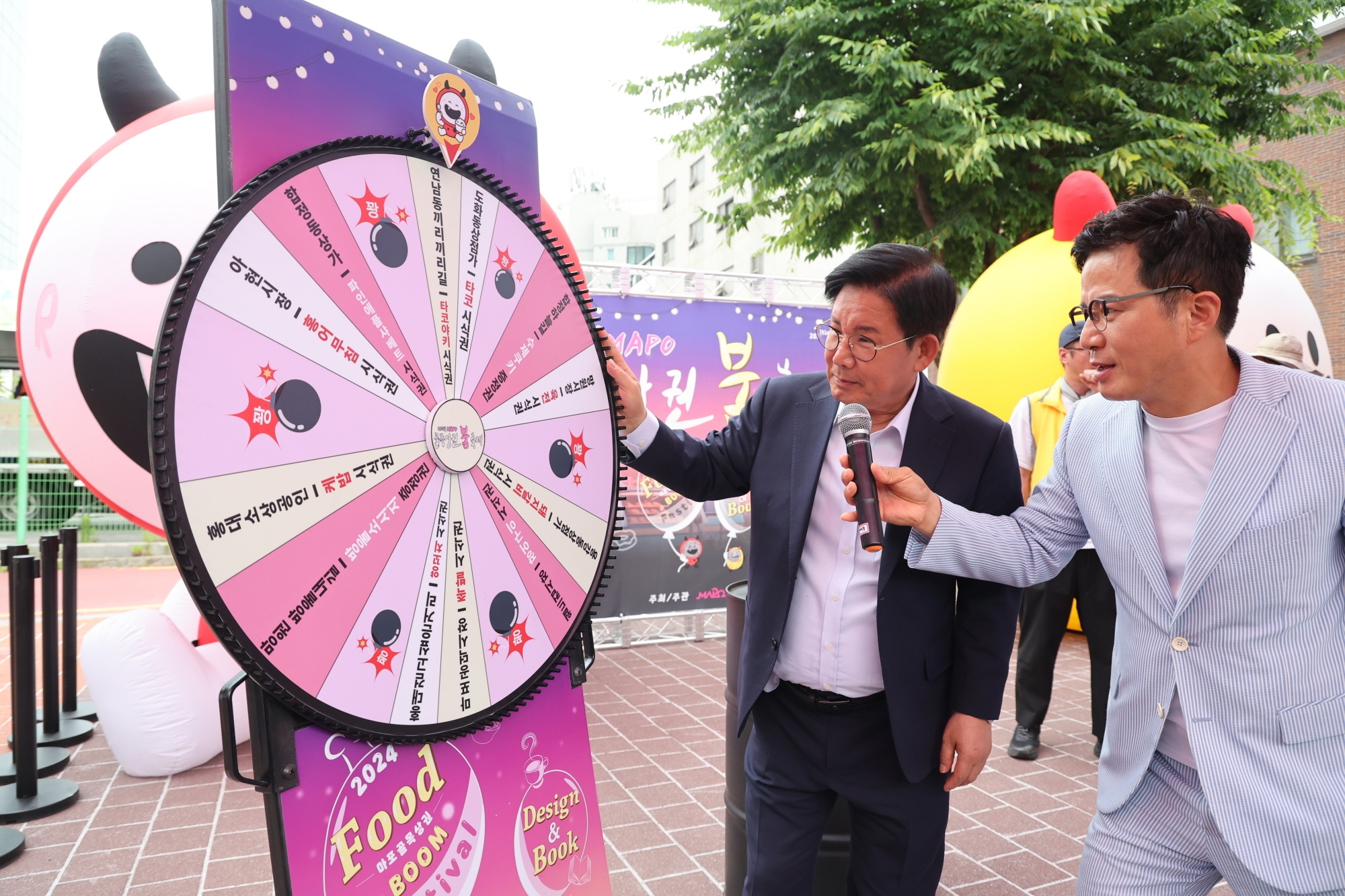 박강수 마포구청장이 조영구 방송인이 진행하는 마포골목상권 붐 축제 행운을 잡아라 행사에 참여해 룰렛을 돌리는 모습./사진제공=마포구