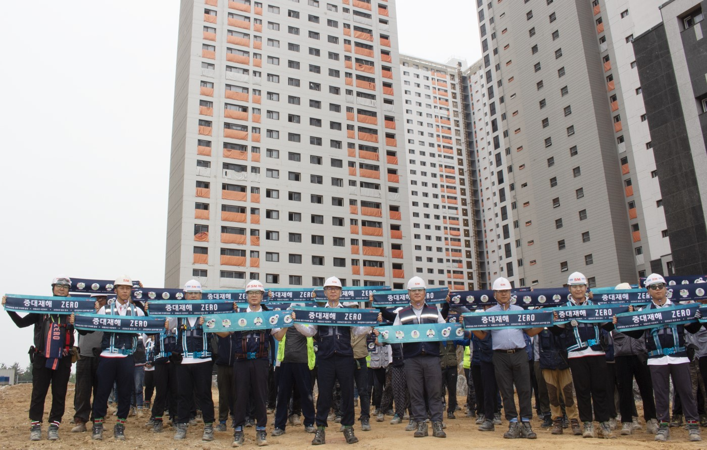 성낙원 SM스틸 건설부문 대표이사(앞줄 왼쪽에서 다섯번째)가 근로자들과 ‘중대재해 ZERO’라고 표기된 타월을 들어 보이며 기념촬영을 하는 모습./사진제공=SM그룹