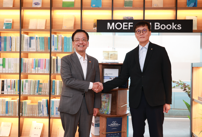 이창용 한국은행 총재(오른쪽)와 최상목 경제부총리 겸 기획재정부 장관(왼쪽)이 30일 타운홀 미팅 전 세종 청사 방문을 기념하며 악수를 나누고 있다. 이 총재가 기재부에 증정한 회전책장 앞. / 사진제공= 한국은행(2024.09.30)
