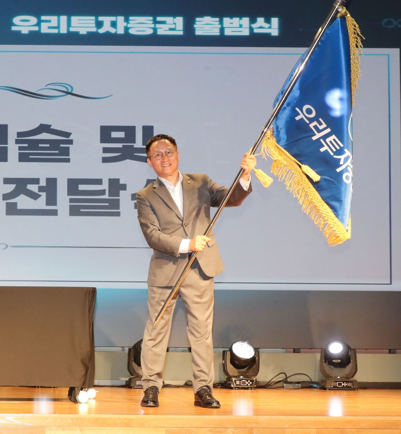 ▲ 2024년 8월 1일 남기천 우리투자증권 대표이사가 여의도 TP타워 소재 본사에서 열린 출범식에서 회사기를 흔들고 있다. / 사진제공 = 우리투자증권