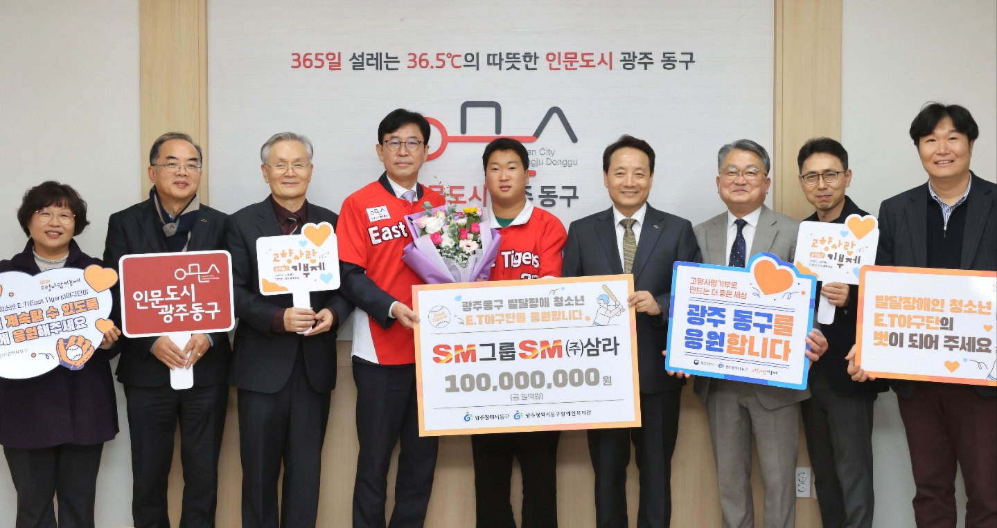 성낙원 SM상선 건설부문 대표(왼쪽에서 네번째)와 임택 광주광역시 동구청장(여섯번째)이 서지원 E.T 야구단 선수(다섯번째)를 비롯한 동구장애인복지관 관계자들과 기념촬영을 하는 모습./사진제공=SM그룹