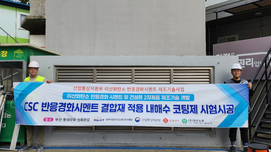 롯데건설 직원들이 부산 롯데타워 현장에서 이산화탄소 반응경화 시멘트를 활용한 코팅제를 시공하고 기념촬영을 하고 있다./사진제공=롯데건설