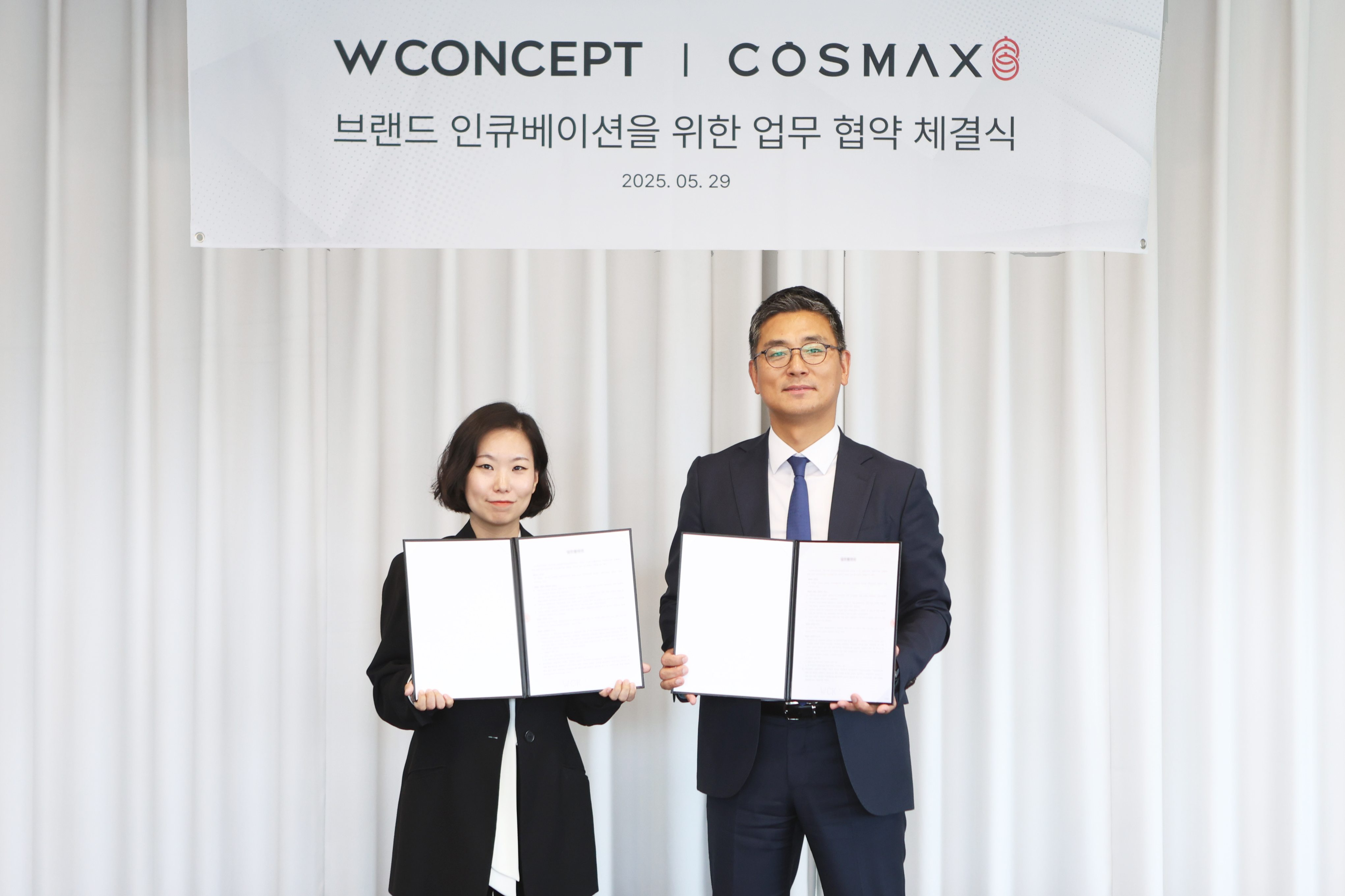 안지수 W컨셉 상품기획담당(왼쪽)과 최재우 코스맥스 국내마케팅본부 부문장(오른쪽)이 업무협약 체결 후 기념사진을 촬영하고 있다. /사진제공=W컨셉