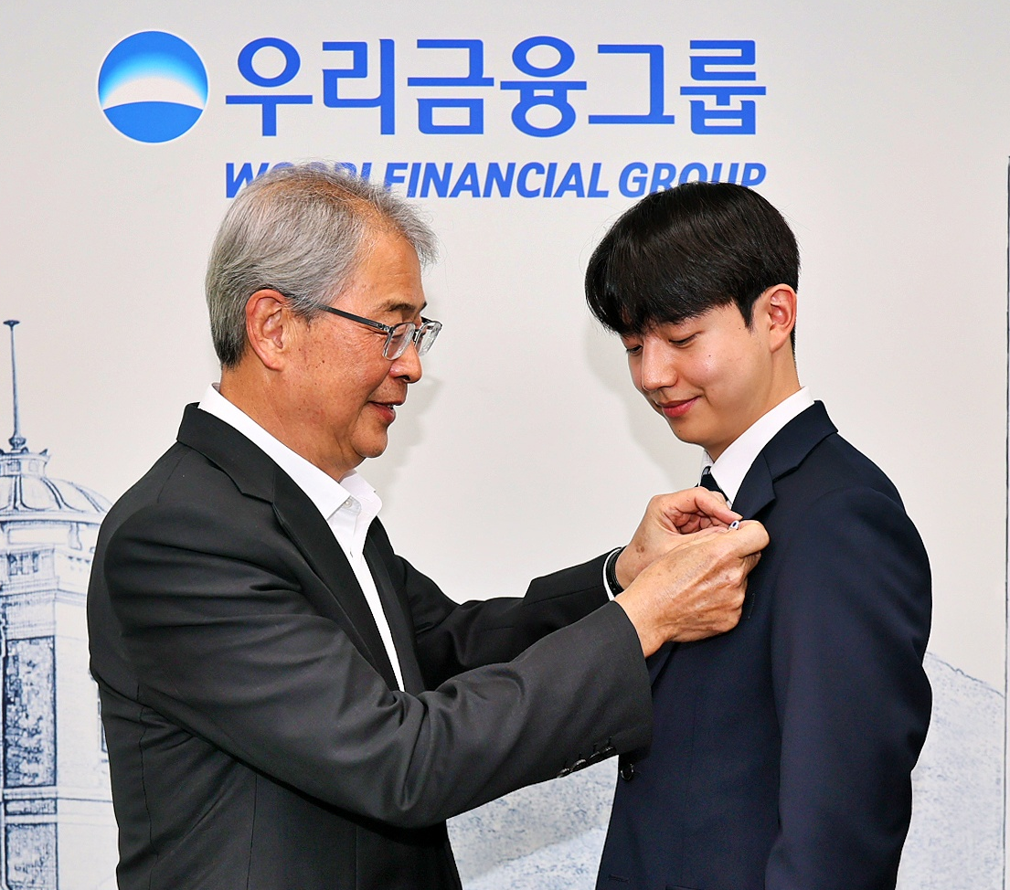 임종룡 우리금융그룹 회장이 1일 자회사 편입을 마친 동양생명·ABL생명 직원에 새로운 그룹 보조휘장을 달아주고 있다. / 사진제공 = 우리금융지주