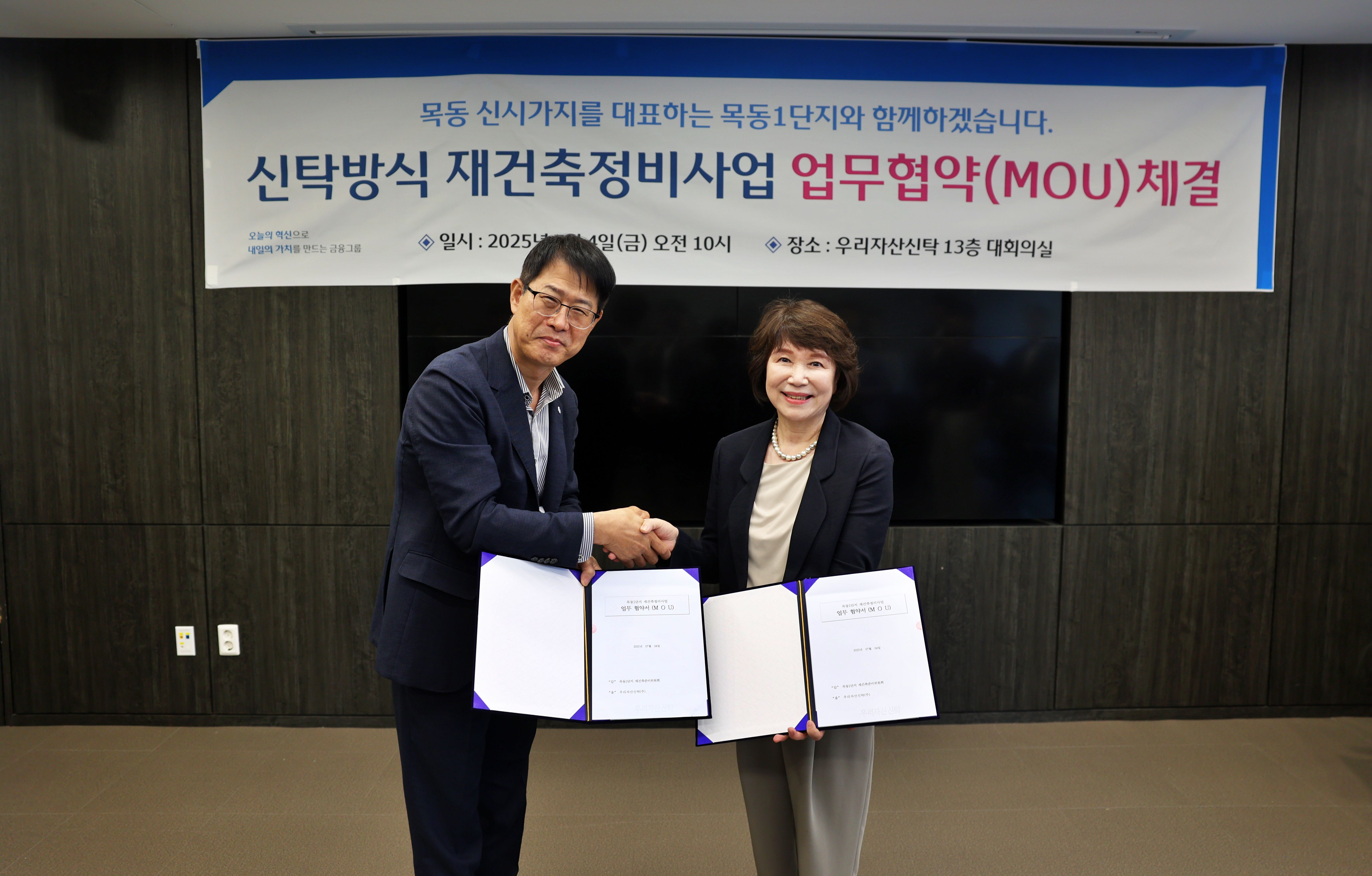 김범석 우리자산신탁 대표(왼쪽)와 정현숙 목동1단지 재건축준비위원장이 재건축 협력을 다짐하며 악수를 하고 있다. /사진제공=우리자산신탁