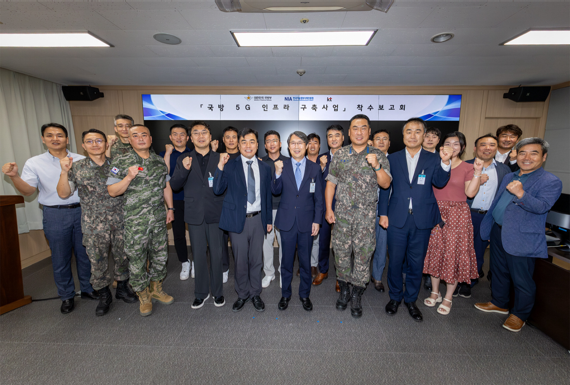 이진권 KT 엔터프라이즈부문 이행1본부장(앞줄 왼쪽부터 6번째)과 국방부, 한국지능정보사회진흥원(NIA) 주요 관계자가 ‘국방 5G 인프라 구축’ 사업 착수보고회에서 단체 기념사진을 촬영하는 모습. / 사진=KT