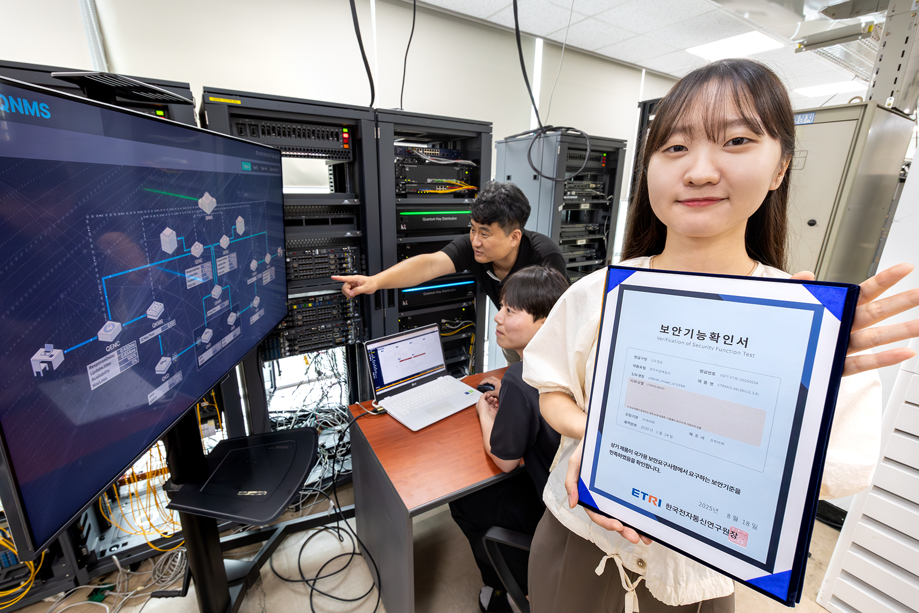 KT는 자사가 개발한 양자키분배(QKD) 기술이 적용된 장비가 국내 제조 장비 중 최초로 국가정보원 보안검증을 통과했다고 25일 밝혔다. 사진은 KT와 코위버 직원이 양자키분배 기술 적용 장비를 점검하며 보안 인증서를 소개하는 모습. / 사진=KT