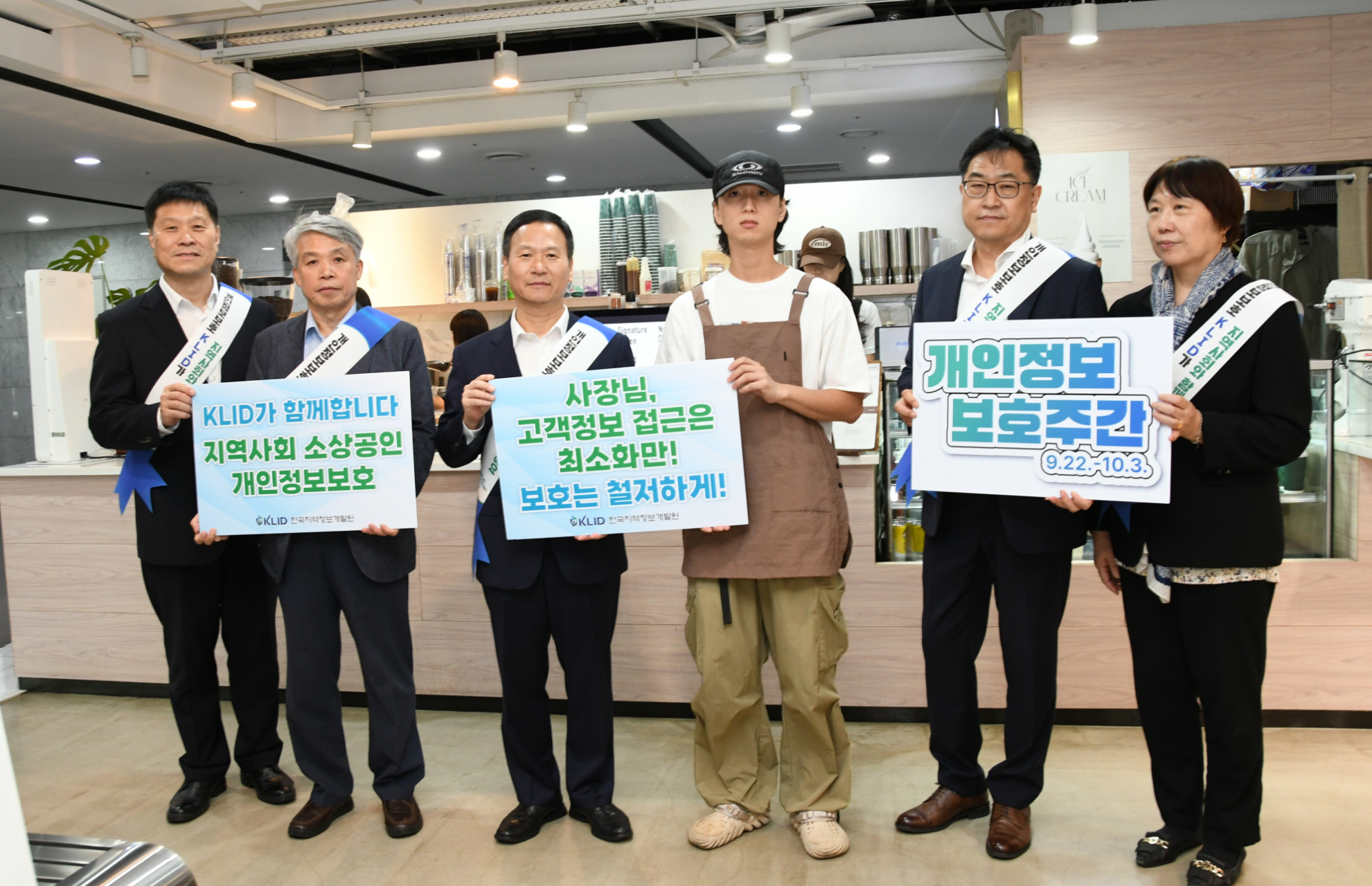 박덕수 한국지역정보개발원 원장(왼쪽에서 세번째)을 비롯한 개발원 임직원과 커피 전문점 관계자가 개인정보보호 안내 팻말을 들고 기념촬영을 하고 있다./사진제공=한국지역정보개발원