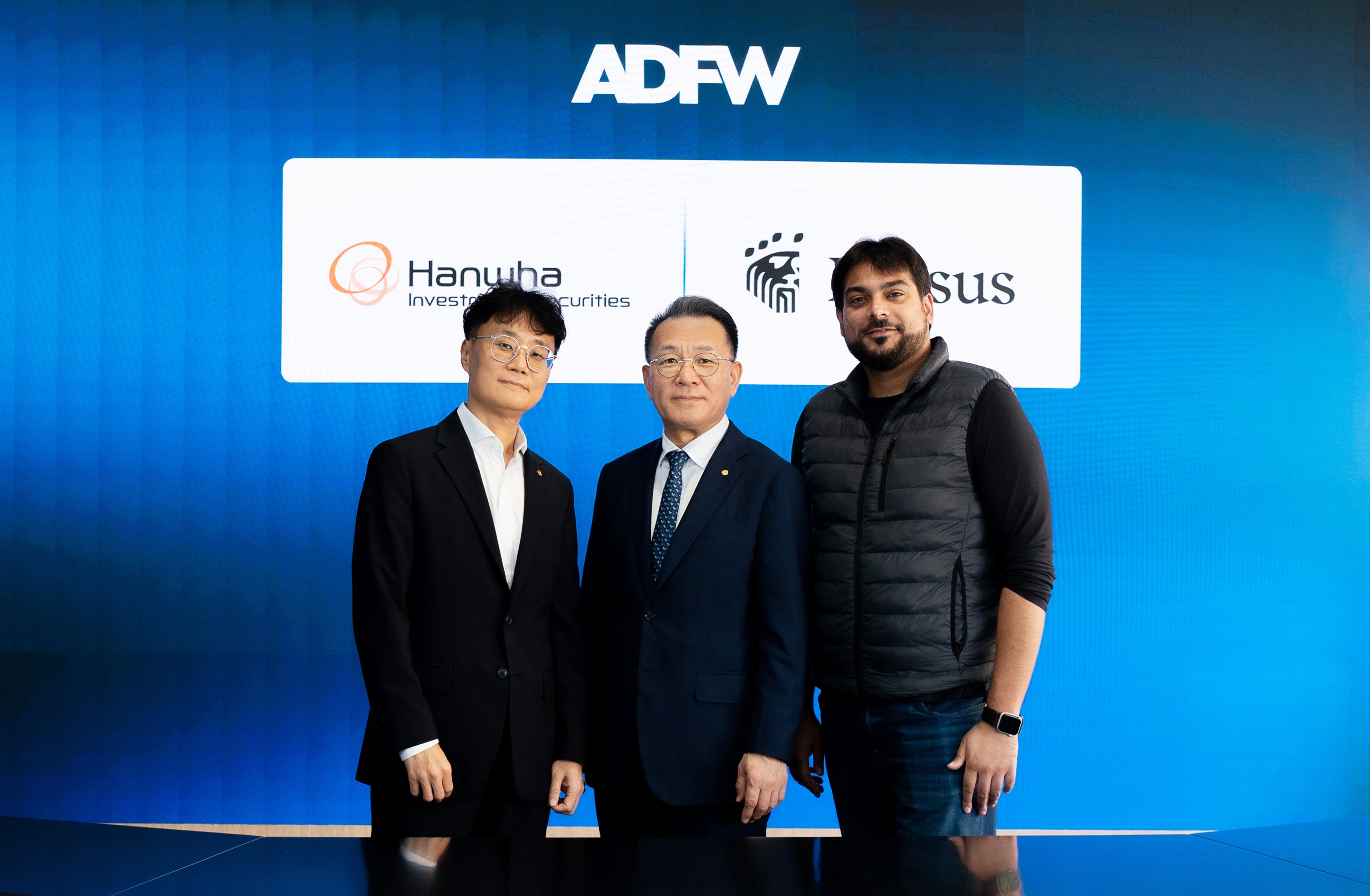 한화투자증권 장병호 대표이사(가운데), 손종민 전무(왼쪽), 크리서스(Kresus) 오메르 칸(Omer Khan) CTO(오른쪽)가 ADFW 2025에서 MOU 체결 후 기념 촬영을 하고 있다. / 사진제공=한화투자증권