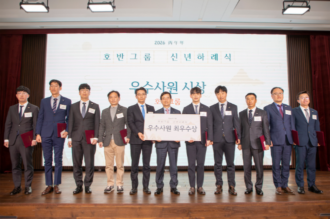 김선규 호반그룹 회장(가운데)이 5일 열린 신년하례식에서 지난해 뛰어난 성과를 거둔 임직원들에게 우수사원상을 수여하고 기념촬영을 하고 있다./사진제공=호반그룹