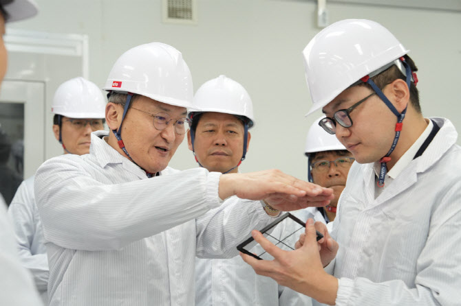 이석희 SK온 사장(왼쪽에서 두 번째)이 5일 대전 대덕구 스탠다드에너지 생산동에서 김부기 스탠다드에너지 대표(오른쪽)로부터 바나듐이온배터리에 대한 설명을 듣고 있다. / 사진=SK온