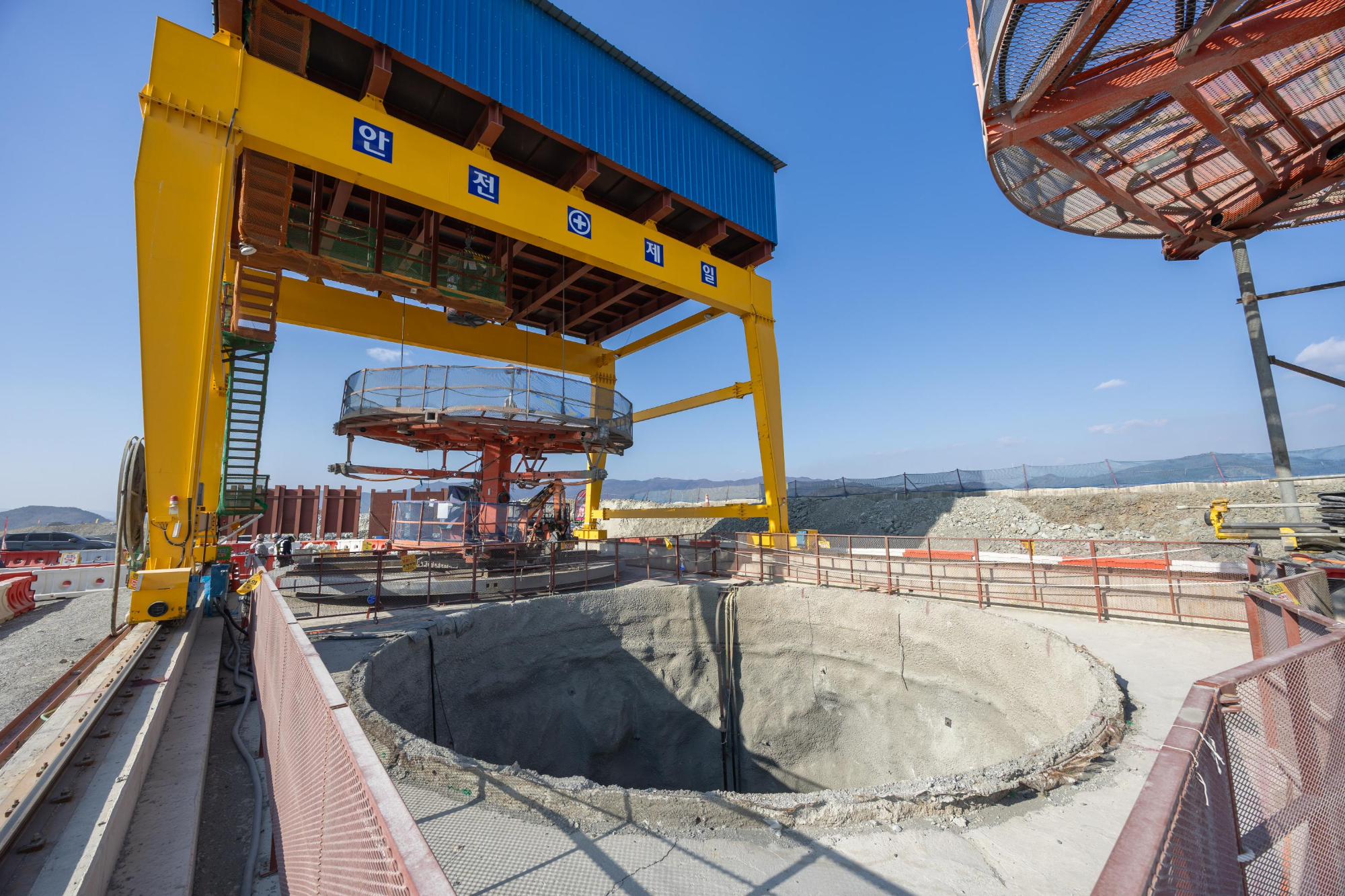 부산항 신항 북측 컨테이너부두 2단계 항만배후단지 조성 공사 현장의 갠트리 크레인 아래에 굴착이 완료된 수직터널 있다./사진제공=DL이앤씨